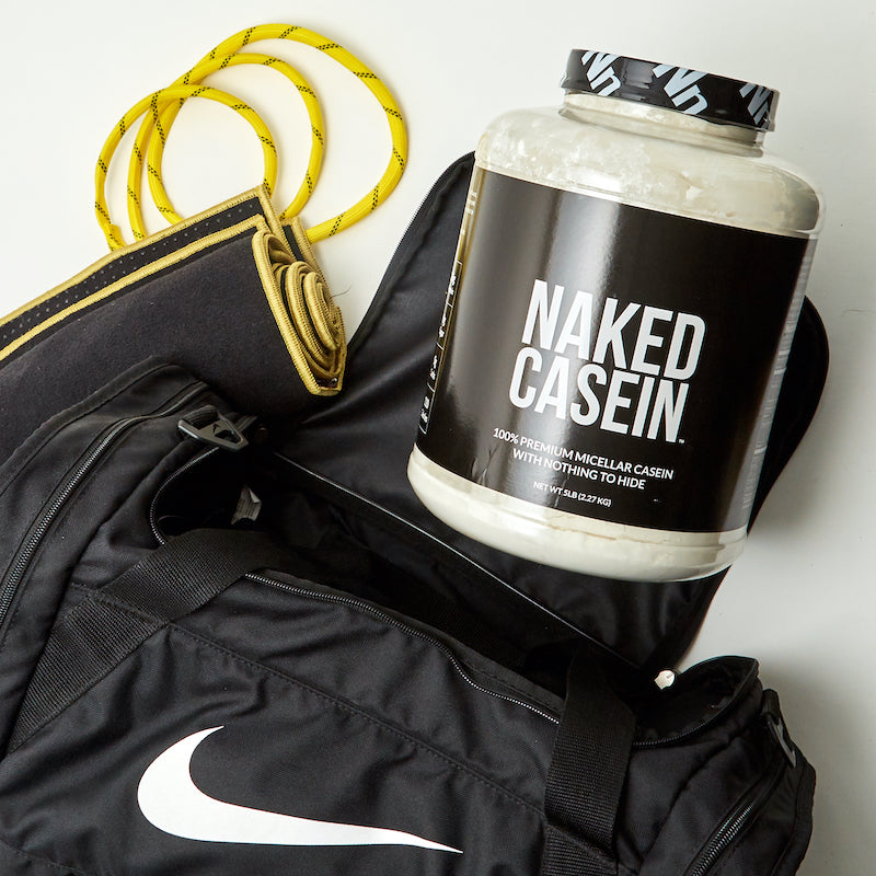 Tub of Naked Casein with a gym bag, skipping rope, and gym mat