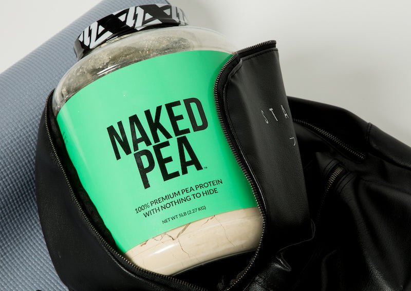 Tub of Naked Pea in a black gym bag leaning against a gym mat