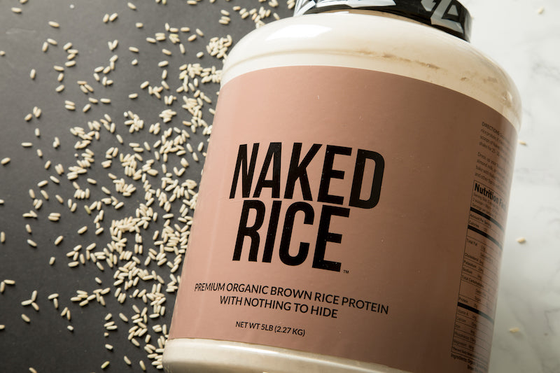 Tub of Naked Rice against a white and black background with rice grains 