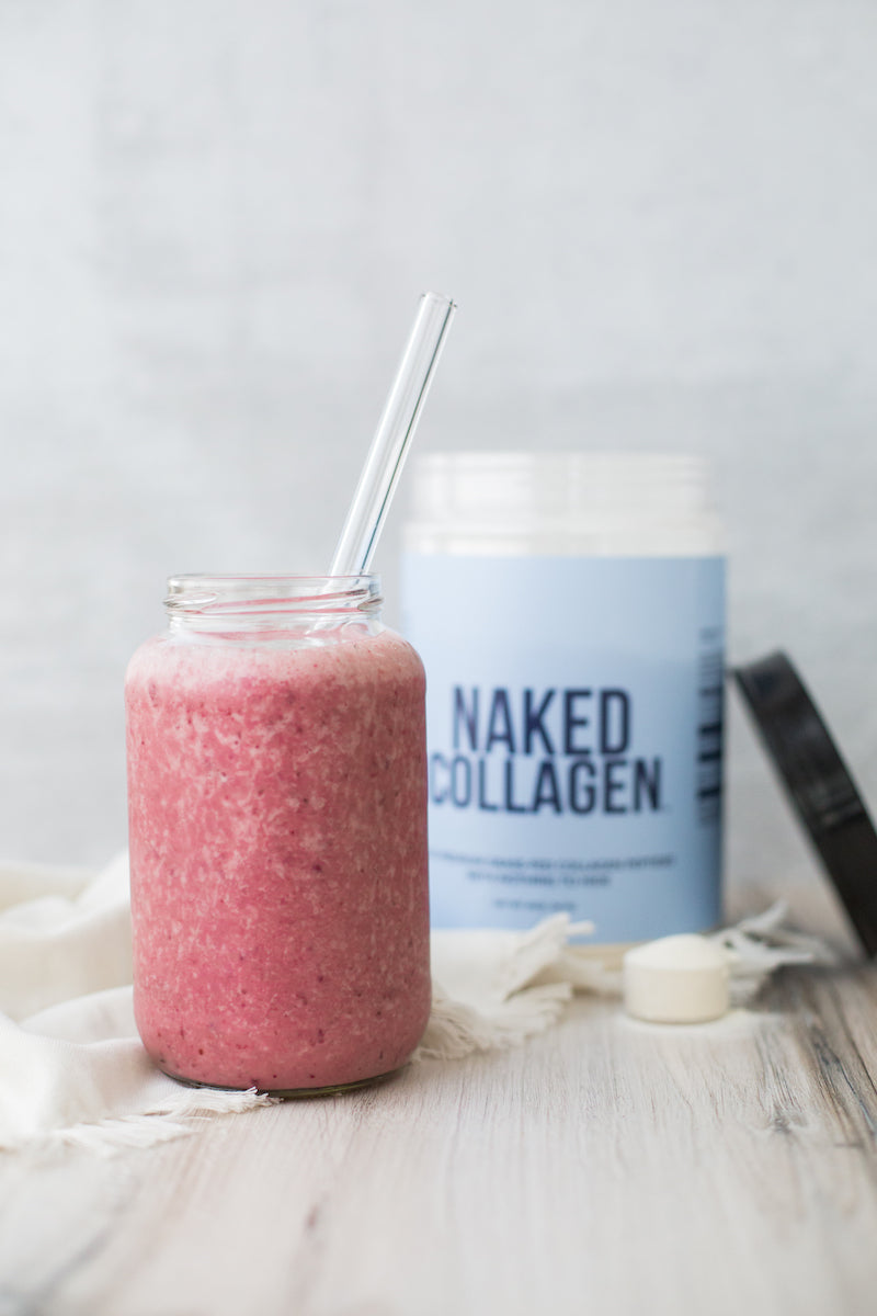 Collagen product image with the tub of Naked Collagen behind a strawberry smoothie