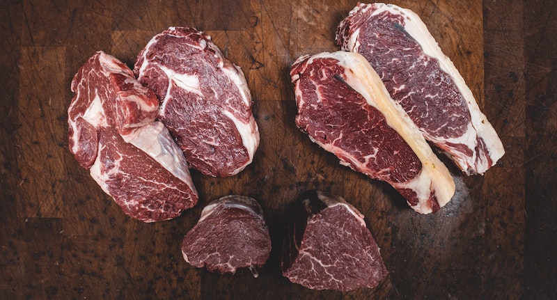 Slices of red meat against a wooden background