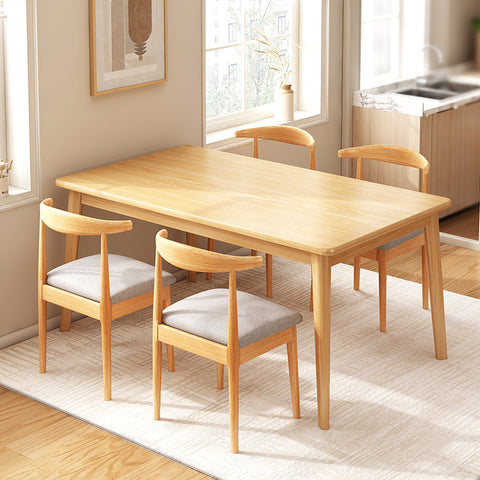 Log-style light-colored solid wood dining table and 4 solid wood dining chairs on a white carpet
