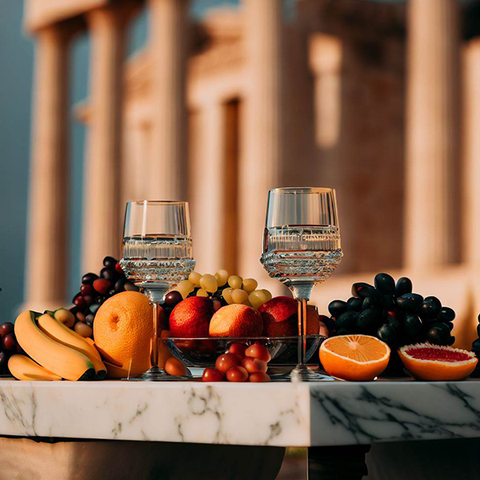 An ancient Greek table with fruits and wine glasses, representing the history of furniture in classical times