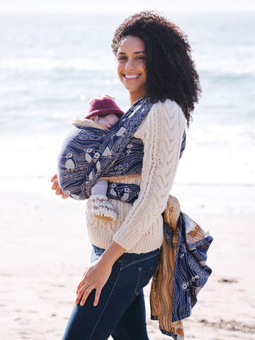 Baby in baby carrier showing hip healthy positioning