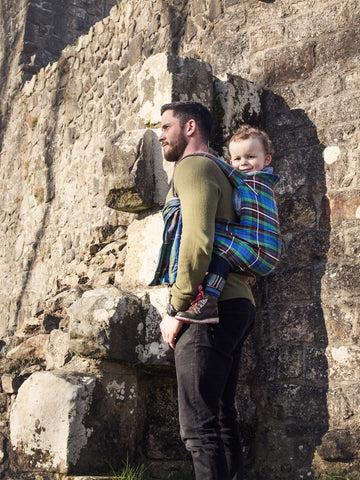 Dad back carrying a toddler on a day out hiking