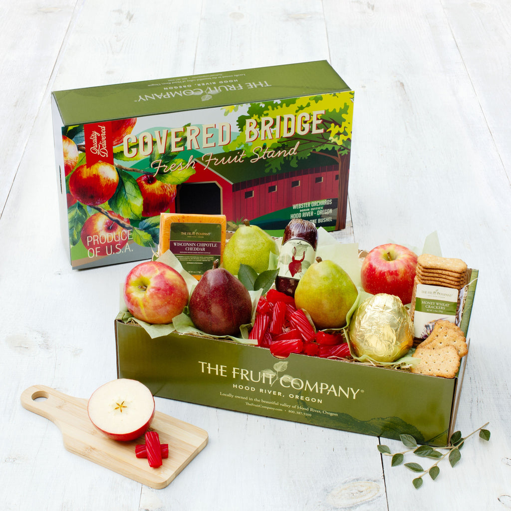 复古盖桥主题的盒子盖，装满了新鲜的水果、肉、奶酪和其他零食