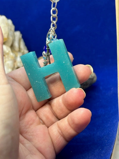 Crafty Angel Art E - Letter - Initial Resin Keychain Aqua solitd Color with Shimmering Mix of Glitter on The Front with Pearls Along with A Décor of Cow Head Along