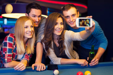 friends take a selfie while playing pool