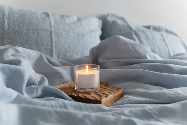 Candle on Bed with Linen Bedding