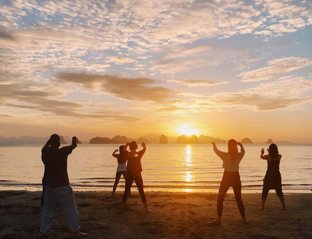 grupo fazendo tai chi chuan ao por-do-sol em retiro espiritual