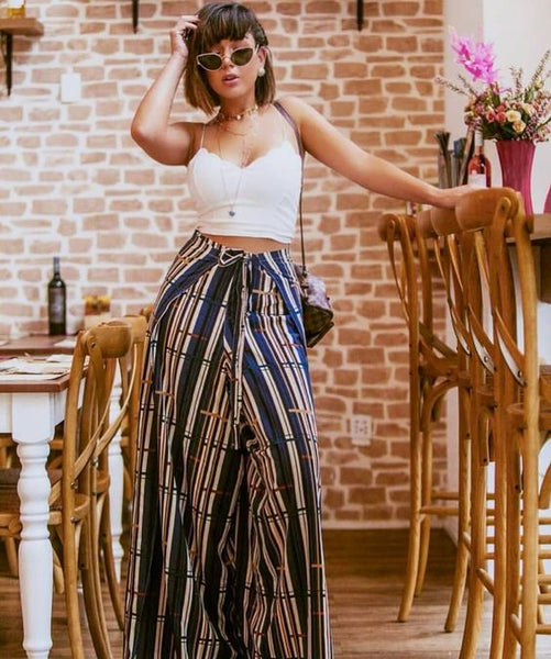 mulher com calça envelope e top branco em estilo ousado