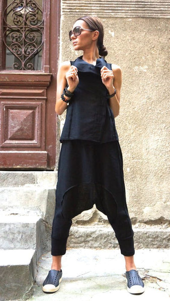 mulher com calça saruel, camiseta e óculos escuros