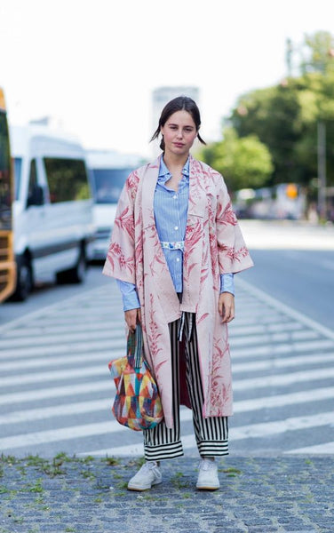 mulher com kimono estampado e calça listrada