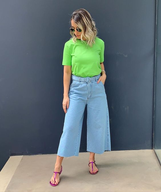 mulher de calça pantacourt jeans, camiseta verde e rasteirinha