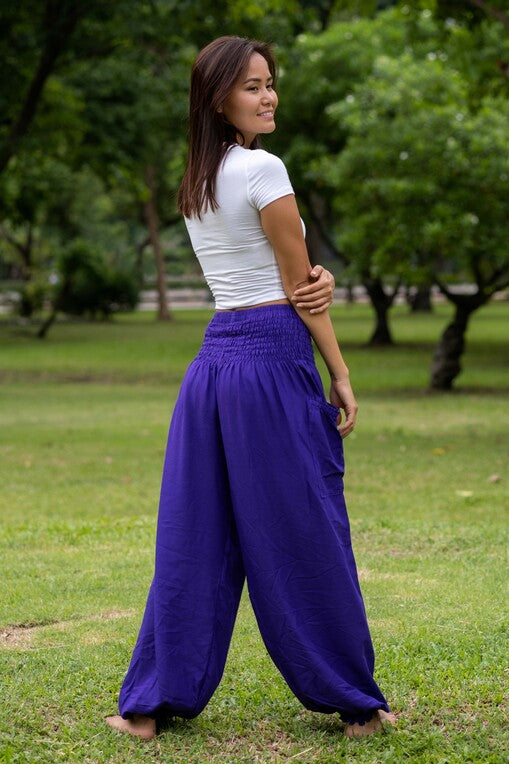 mulher de pé na grama usando calça jasmine e camiseta branca