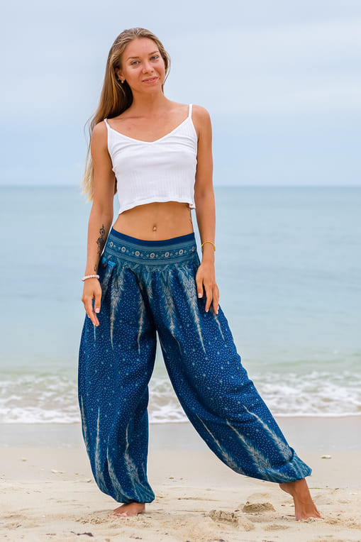 mulher de pé na praia usando calça jasmine e top branco