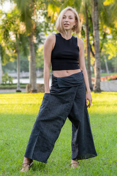 mulher de pé na grama usando calça envelope da Calça Thai e top preto