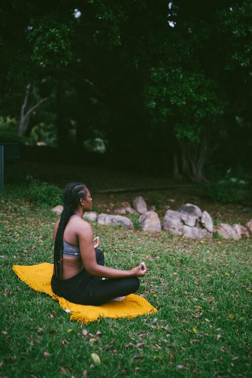 mulher meditando em gramado de retiro espiritual