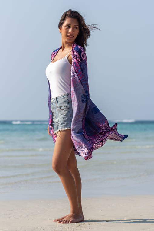 mulher na praia de short, kimono feminino estampado e regata