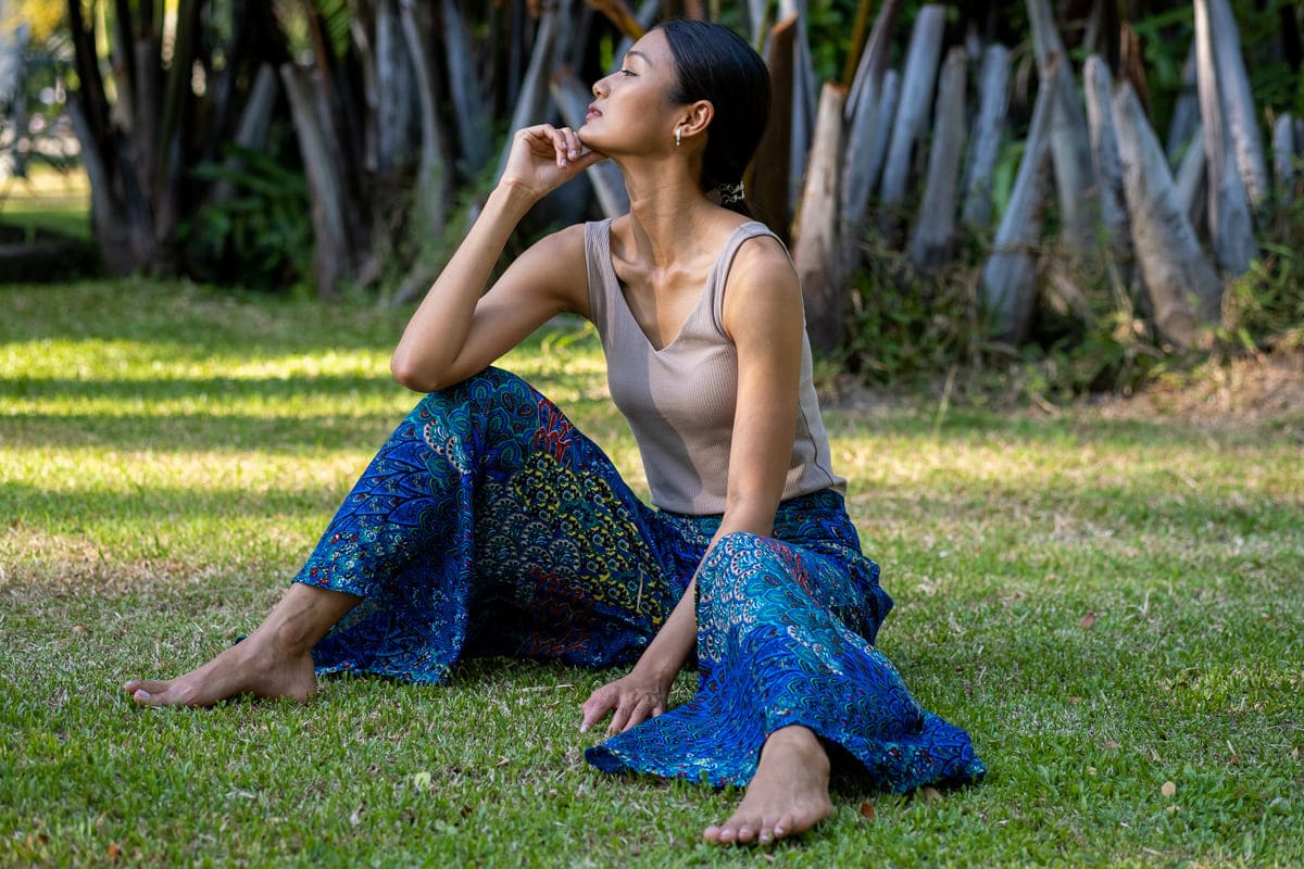 mulher sentada na grama usando calça palazzo