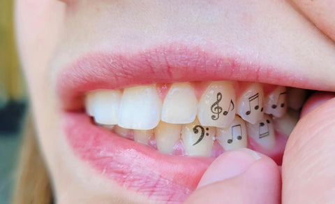 A temporary tooth tattoo or tattooth on multiple teeth with music notes