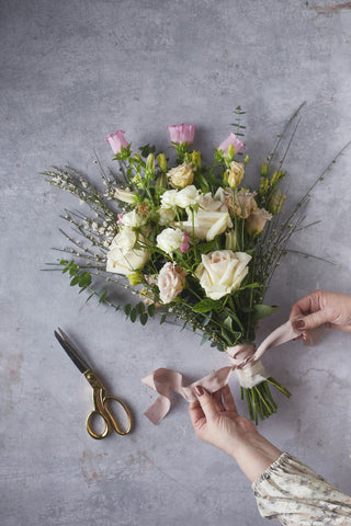 a person making a bouquet of flowers