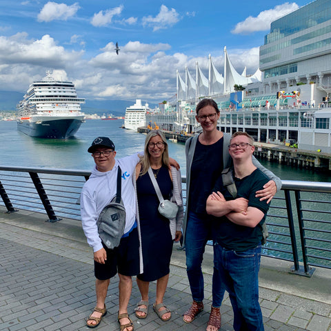 four people stand in front of Canada Place as a cruise ship arrives