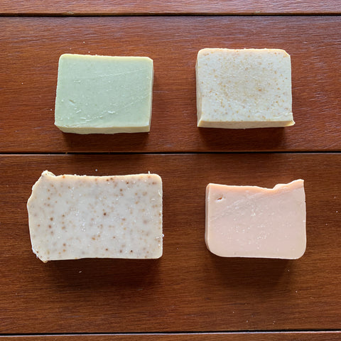 four bars of soap on a wood table