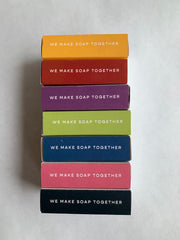 colourful packages of soap that read "we make soap together"