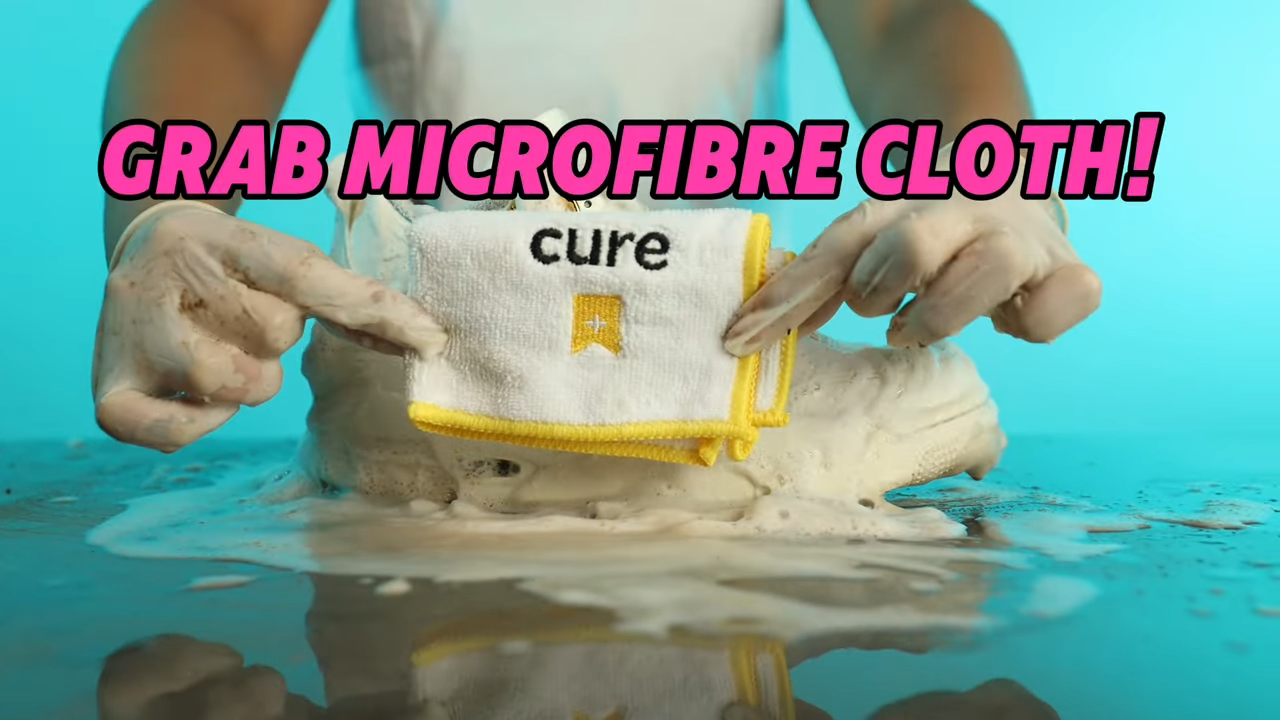 Grabbing a Microfibre Cloth from the Cure Kit and wiping down the Air Jordan 4s