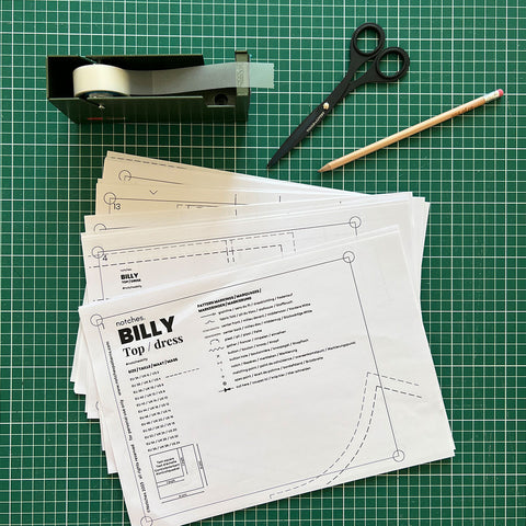 Pile of printed A4 US letter pages of the Billy sewing pattern with scissors and tape