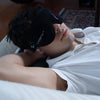 man sleeping in bed wearing noise cancelling earplugs and men's sleep mask 