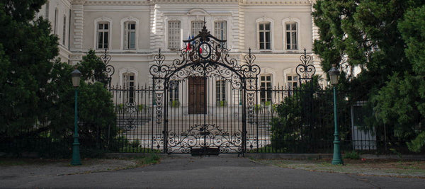 wrought iron gate with large house in background