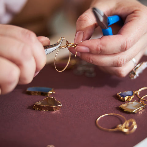 A master jeweler uses tools to create a custom design jewelry piece. 
