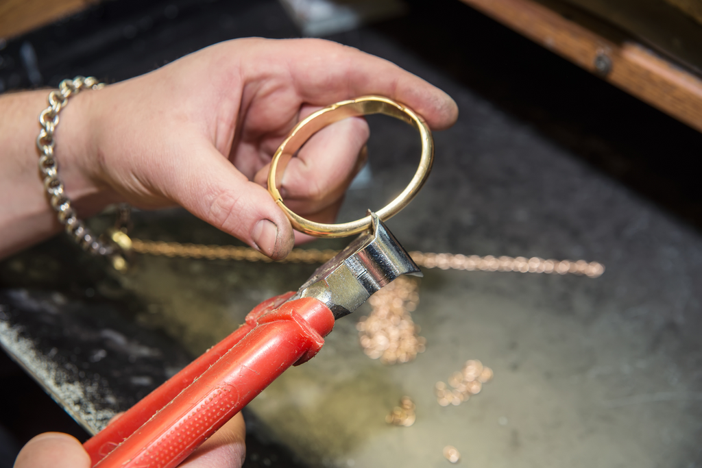 A jeweler engraves a bracelet by hand. 