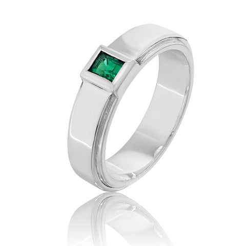 A platinum men's wedding band with a green gemstone in the center. 