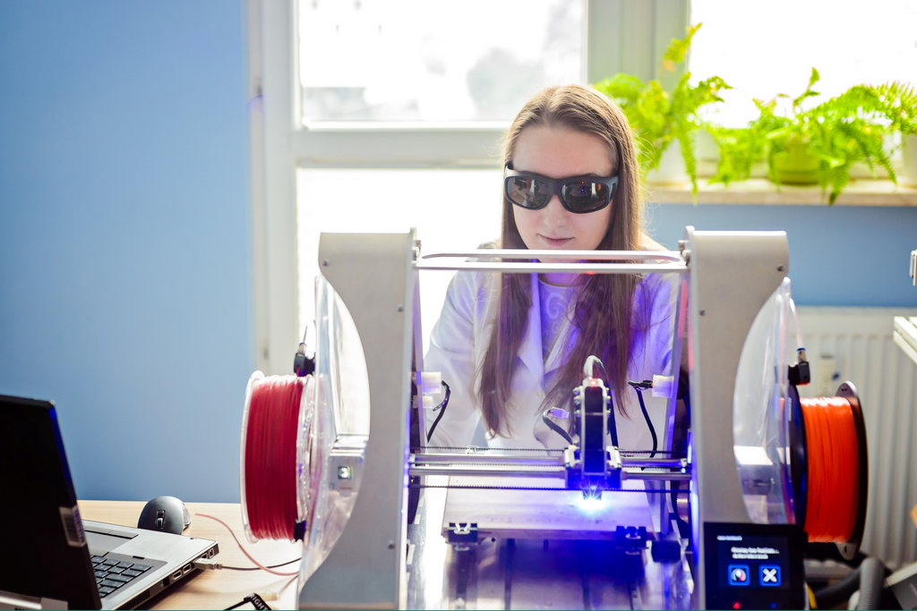 An engraver uses a laser engraving machine to add custom designs to antique jewelry.