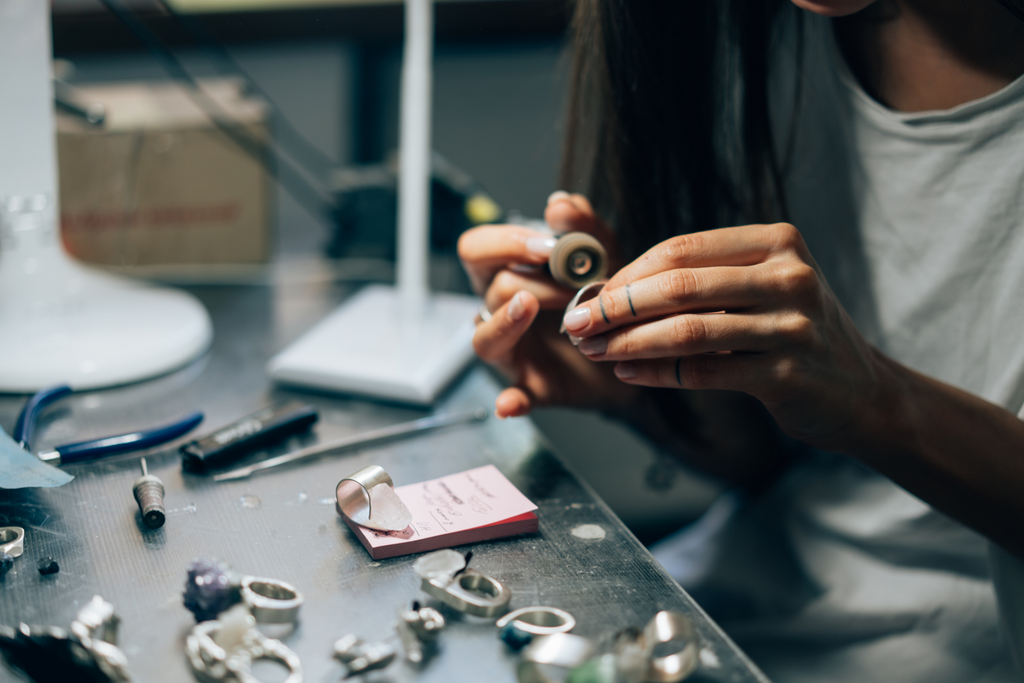 A jeweler engraves a delicate piece of jewelry. 