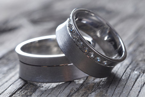 A pair of tungsten wedding bands. Choosing the right men's wedding band size requires considering the material of the ring.