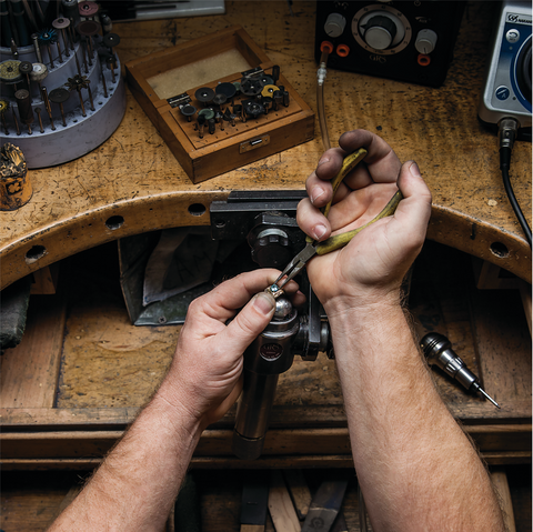 A master jeweler works with custom design jewelry for a customer. 