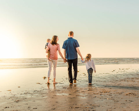 family walking on the beach into the san diego sunset