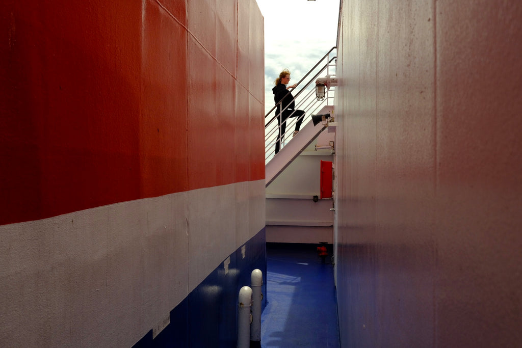 Passenger climbing stairs on outside deck of Brittany Ferries vessel.