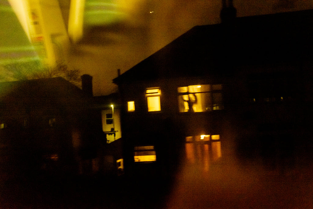 figure in upstairs window appearing to want to escape as seen from passing train across south London