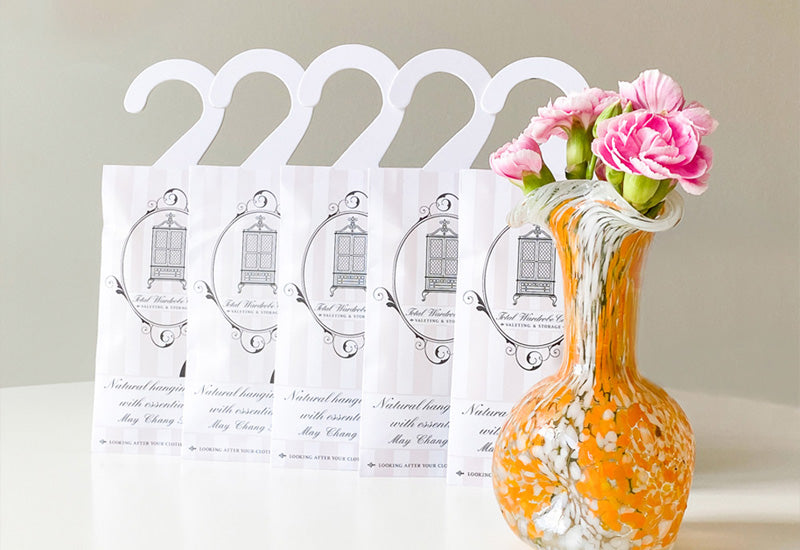 May chang blend hanging sachets stood lined up next to glass vase