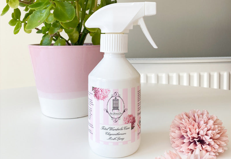 250ml bottle of Chrysanthemum moth spray stood on white surface with pink and white plant pot behind