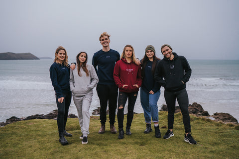 7 people on a Cornish headland wearing cove clothing products