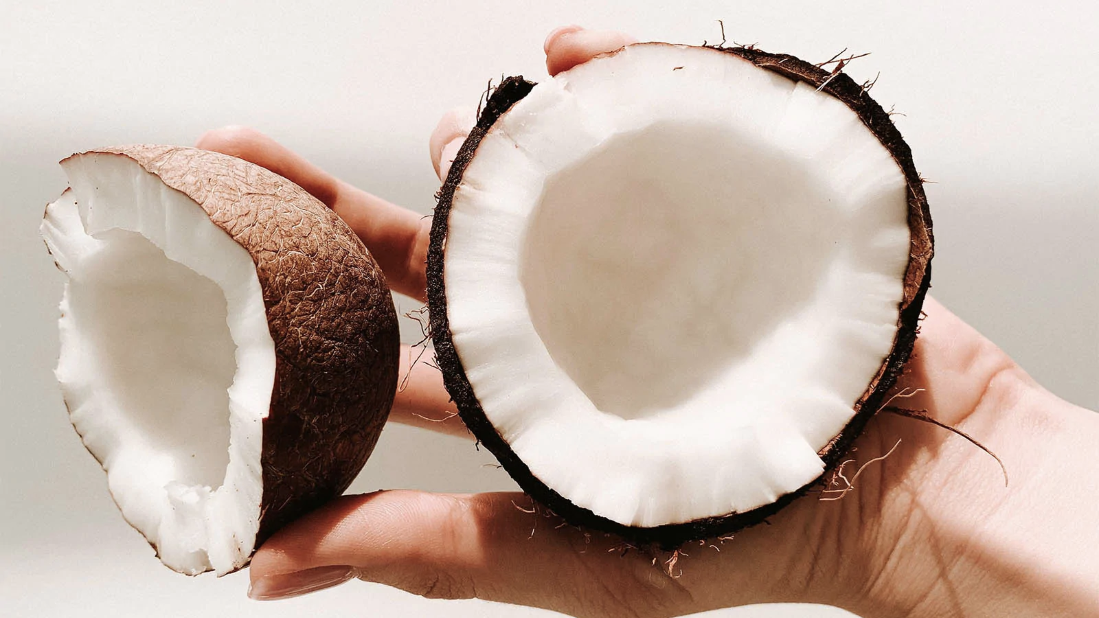 Hand som håller en öppen kokosnöt