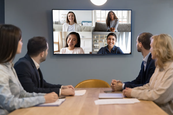 A group of executive engaging with coworkers during a virtual meeting