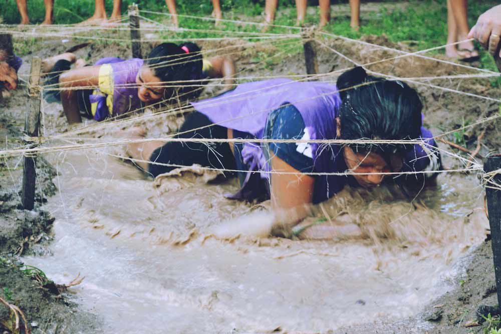 Woman taking on new challenge getting through the mud