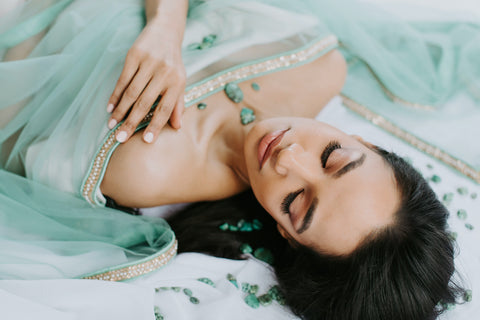 turquoise stones on model lying down with teal shawl